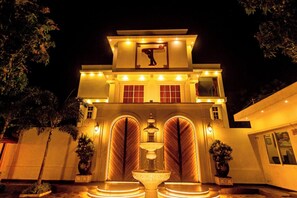 A large, well-lit building with a prominent entrance, a fountain, and multiple windows. - T Resort (Vanur)