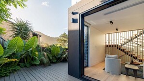 Ein modernes Interieur mit Treppe, einer Sitzecke und Blick ins Freie.