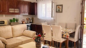 Un salon comprenant un canapé, une table basse et un coin repas avec des chaises.