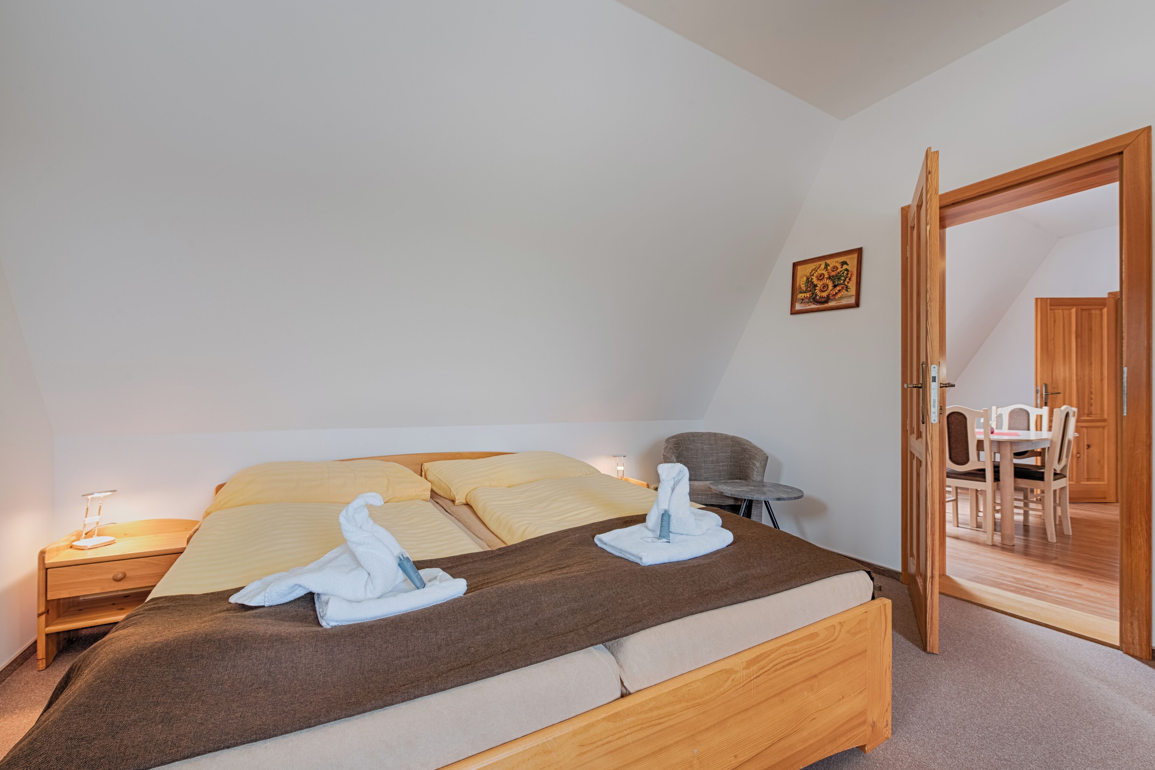 A bedroom with a bed, bedside table, and a chair.