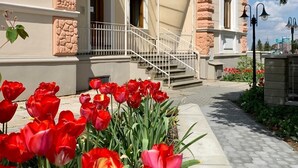 A building with a stone facade, a sign reading 'KAVARNAVILAMACHU,' and a staircase leading to the entrance. - Penzion Vila Machů (Kopřivnice)