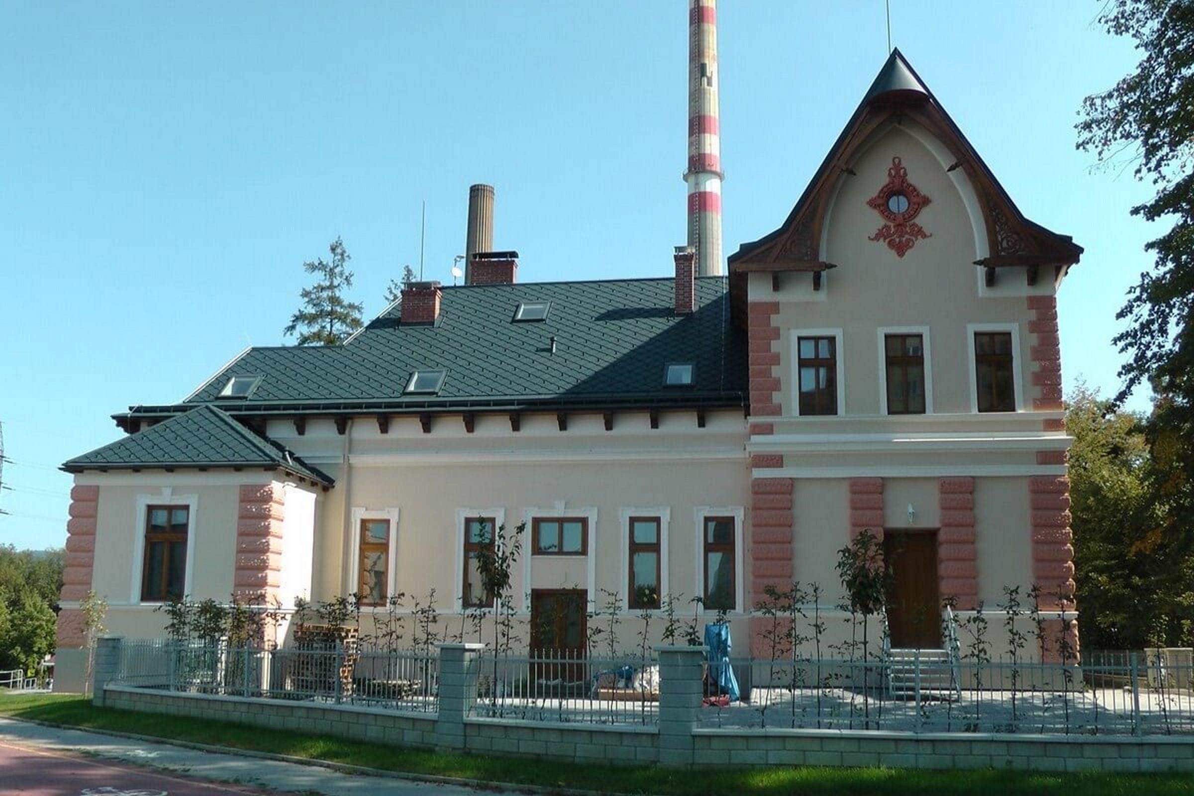 Un bâtiment à deux étages, doté d’un toit à pignon, d’une cheminée et d’un motif décoratif sur la façade.
