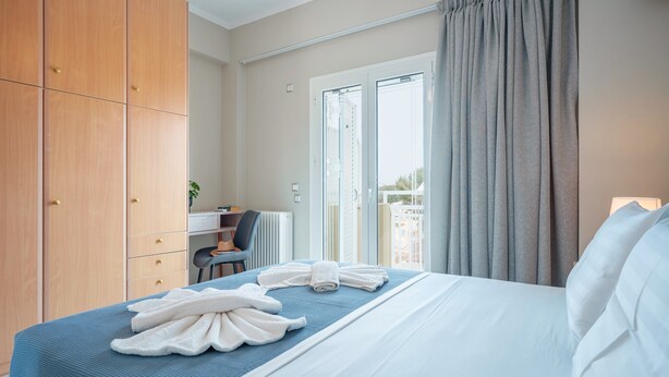 Ett hotellrum med en säng, ett skrivbord, en stol och utsikt över omgivningarna.