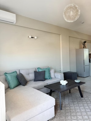 Ein modernes Wohnzimmer mit Sofa, Couchtisch und einer Pendelleuchte.