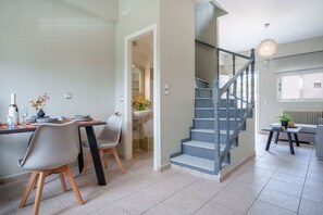 Ein modernes Interieur mit Essbereich, Treppe und Wohnbereich.
