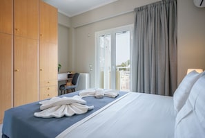 Ein Hotelzimmer mit Bett, Schreibtisch, Stuhl und Blick ins Freie.