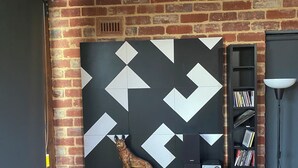 Une pièce comprenant un bureau en bois, une bibliothèque, une lampe et une statuette de chien décorative.