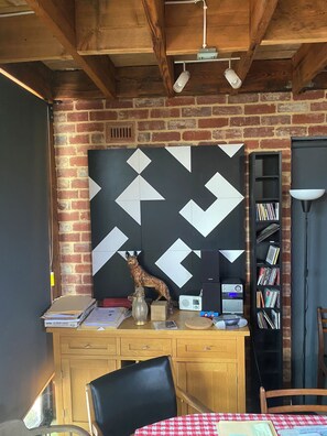 Ein Zimmer mit einem Holztisch, einem Bücherregal, einer Lampe und einer dekorativen Hundestatue.