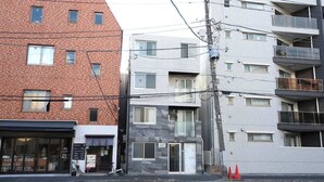 Um edifício de vários andares com fachada de tijolos e um edifício de vidro moderno adjacente.