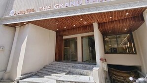 The entrance to The Grand Bhagwat Hotel with a wooden canopy, stone steps, and glass doors. - Hotel The Grand Bhagwati (Dwarka)