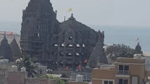 A traditional temple with a pointed spire, surrounded by residential buildings. - Hotel The Grand Bhagwati (Dwarka)