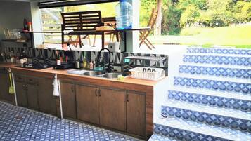Une cuisine dotée d’un plan de travail en bois, de deux éviers et d’un grand distributeur d’eau.