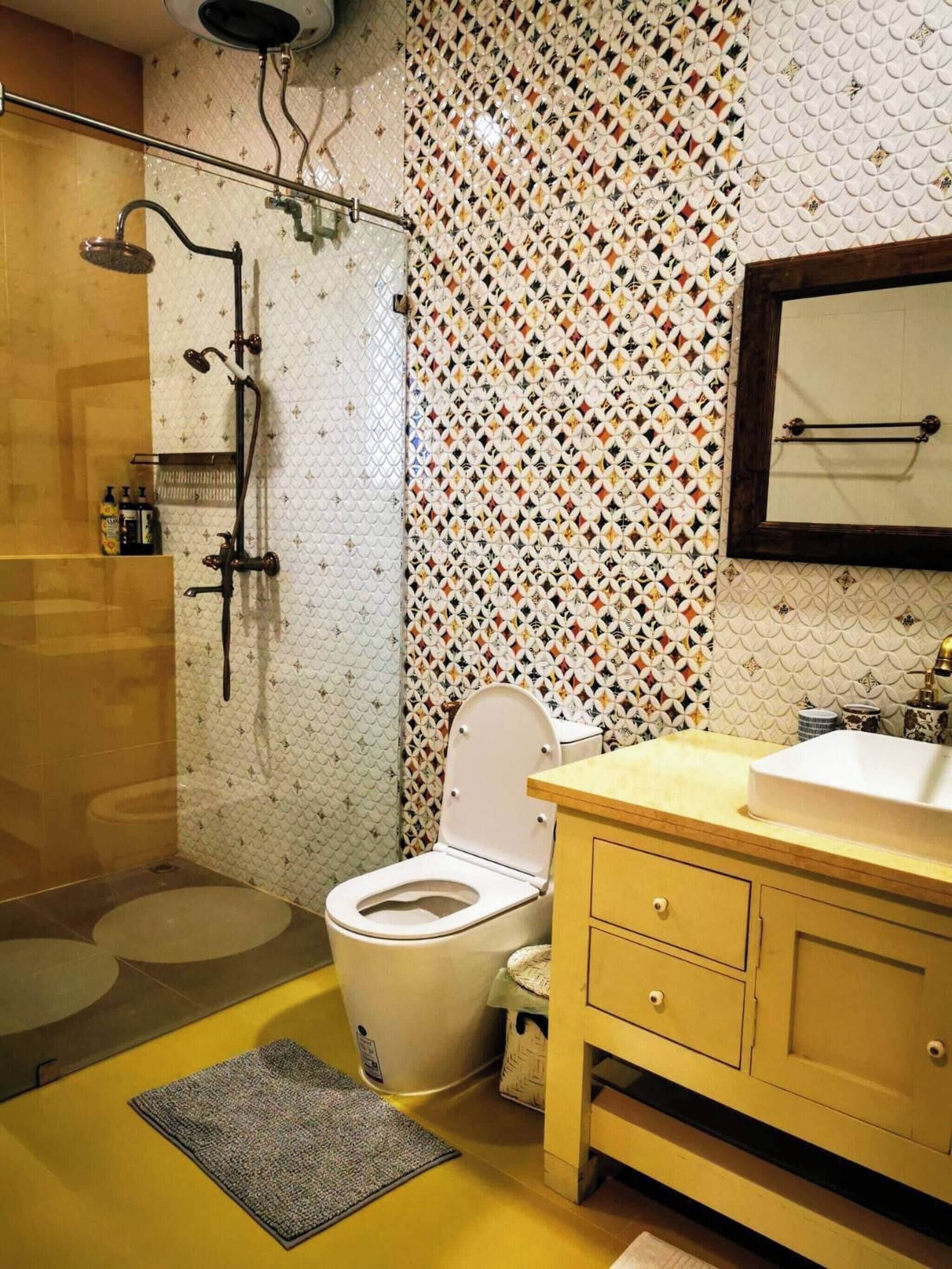 Een badkamer met douche, toilet, wastafel en spiegel.
