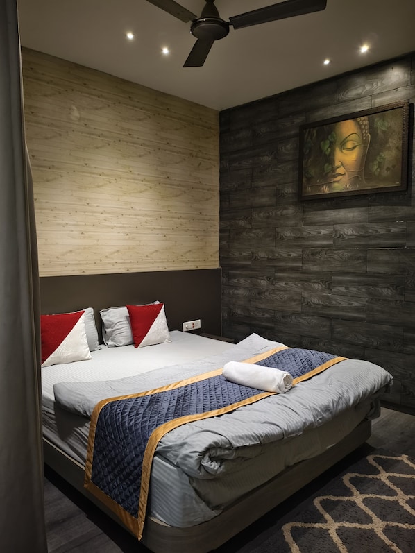 Une chambre moderne avec un lit, un ventilateur de plafond et un tableau accroché au mur.