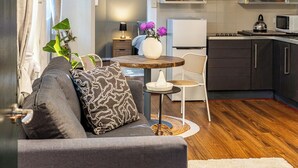 Un salon moderne avec un canapé, une table à manger et une cuisine en arrière-plan.
