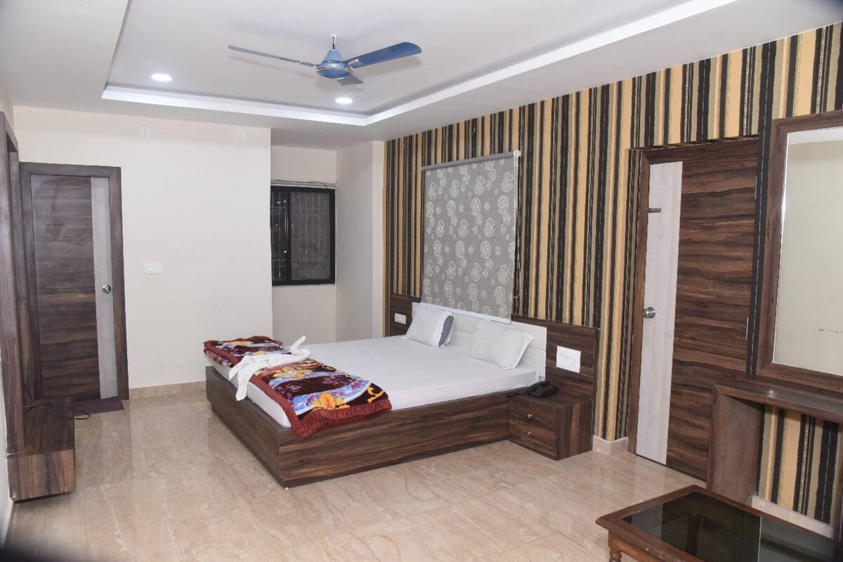 Un dormitorio con cama, mesita de noche y ventilador de techo.