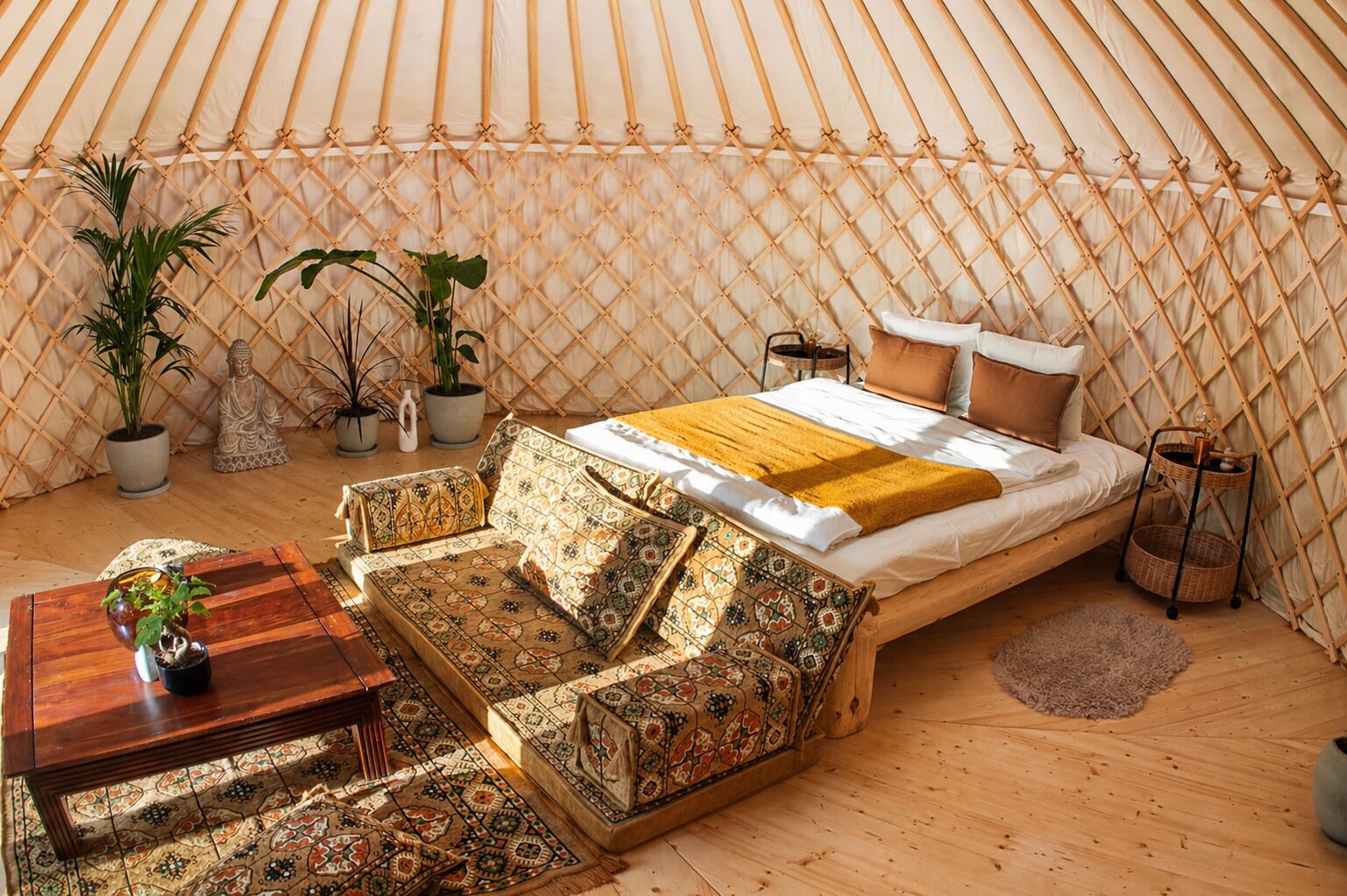 Um ambiente acolhedor com cama, sofá e plantas em vasos.