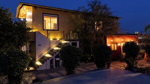 A two-story house with a staircase, a large window, and outdoor lighting.