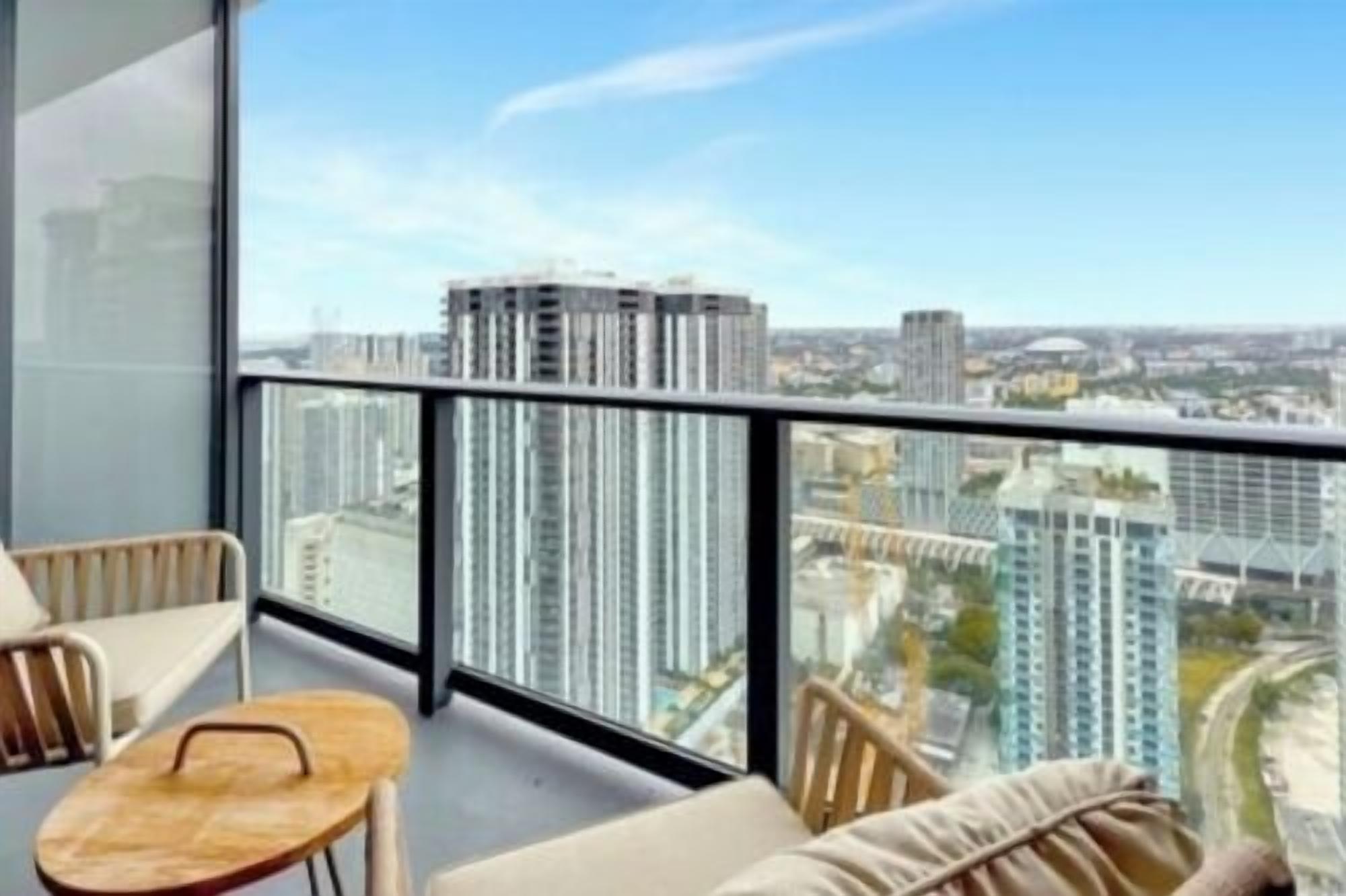 A balcony with a city view, furnished with a sofa and a small table.