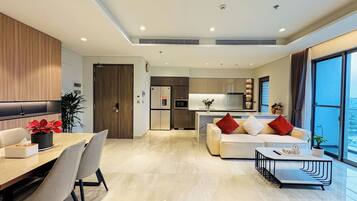 A modern living room with a sofa, dining table, and chairs.