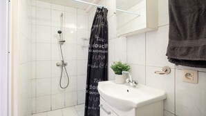 Ein Badezimmer mit Dusche, Waschbecken und Handtuchhalter.
