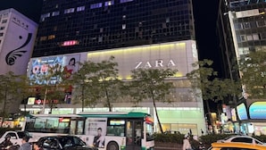 A building with a Zara store on the ground floor, surrounded by trees and busy street traffic. - STAG Haven (Taipei)