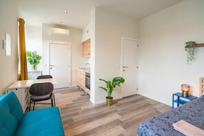 A modern apartment with a dining area, kitchenette, and a living room with a sofa and a bed. - Antwerp central city apartment (Antwerp)