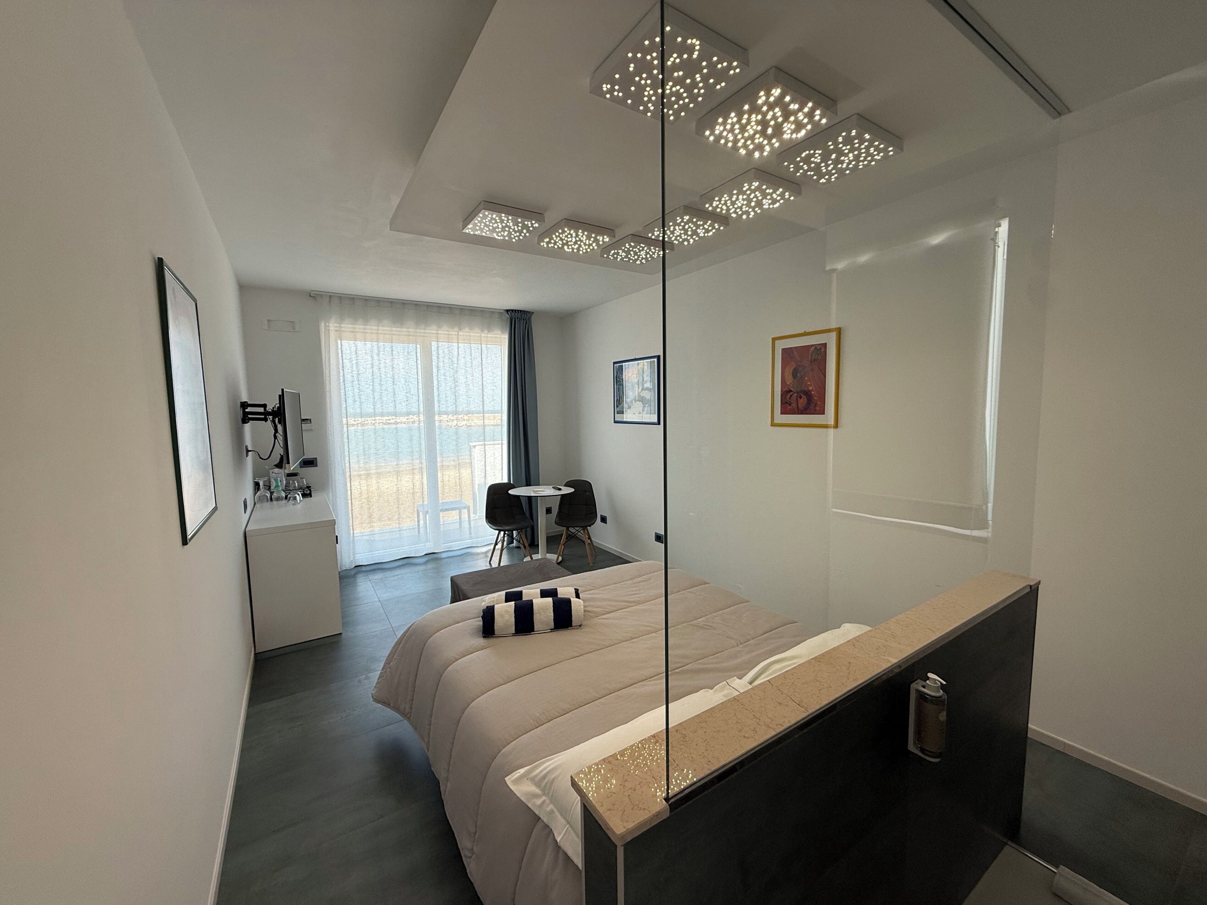 Un dormitorio moderno con cama, escritorio y silla.