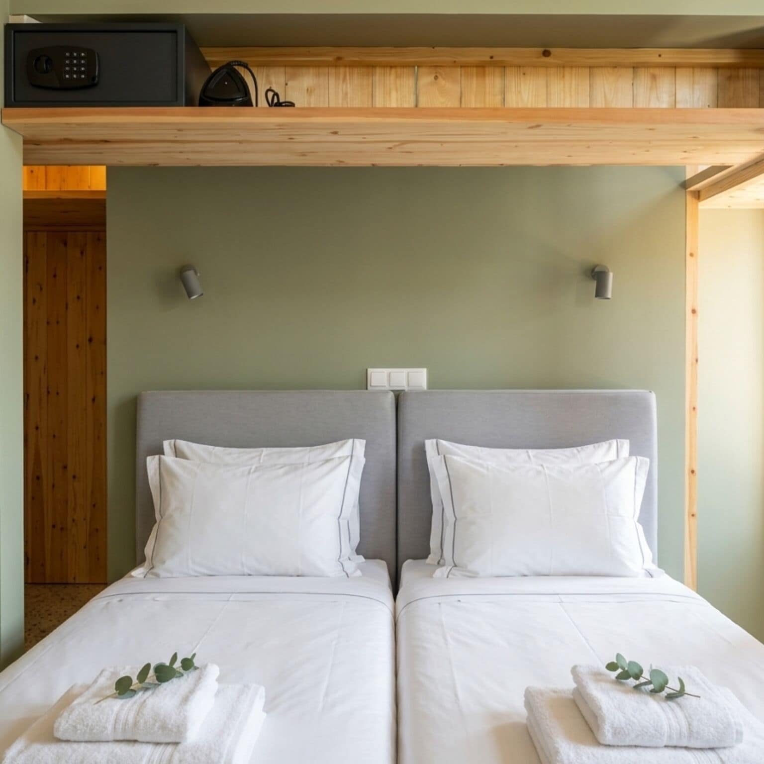 A twin room with two beds, a wooden ceiling, and a small heater on the wall.