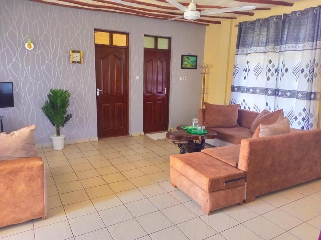 Departamento familiar, vista al jardín | Área de sala de estar | Smart TV de 24 pulgadas con canales digitales 