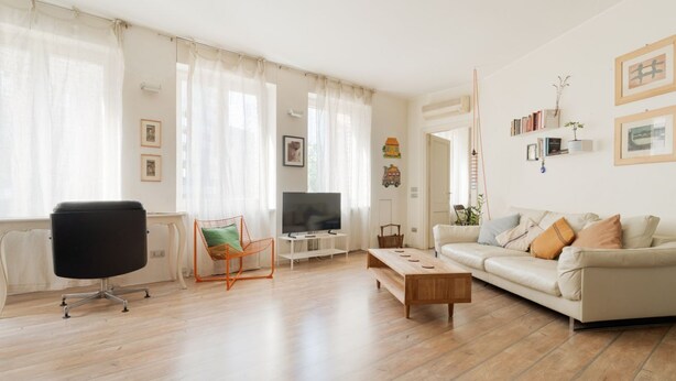 Ein Wohnzimmer mit Sofa, Couchtisch, Fernseher und Sessel.