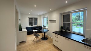Una cocina moderna con comedor, sofá y ventanas amplias.