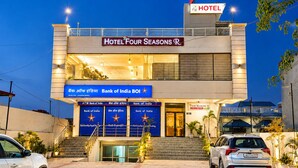 Un hotel con un cartel que dice 'Hotel Four Seasons R' y un cartel de 'Bank of India' debajo.