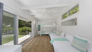 A room with a bunk bed, a ceiling fan, a large window, and a view of greenery outside. - Pet friendly,pool + stroll to beach and cafe (PEARL BEACH)