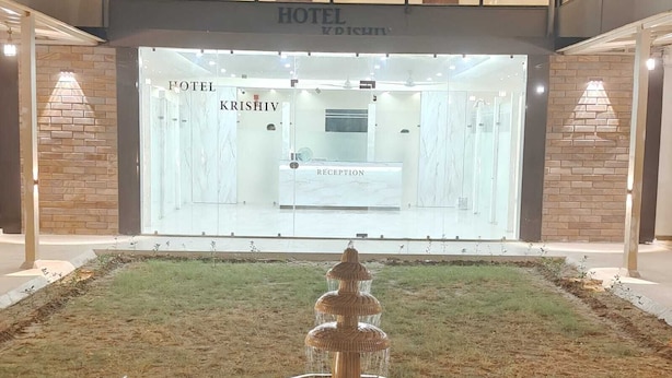 A hotel reception area with a reception desk, a fountain, and a brick wall.