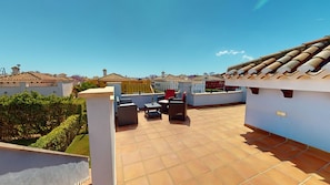 A rooftop terrace with tiled flooring, outdoor furniture, and a view of surrounding buildings. - Villa - Stay6 - Garden - Parking - Pool - Golfarea (Torre-Pacheco)