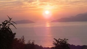 Un atardecer sobre un cuerpo de agua tranquilo con formas de tierra a lo lejos.