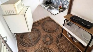 Una cocina compacta con microondas, fregadero y estufa.
