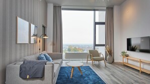 Ein modernes Wohnzimmer mit einer Couch, einem Sessel und einem Fernseher.