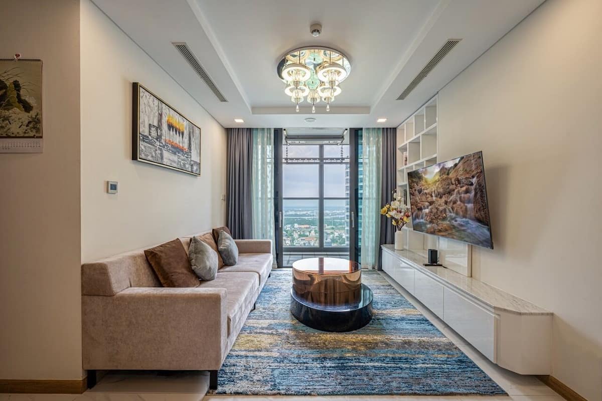 A modern living room with a sofa, a coffee table, a TV, and artwork on the walls.