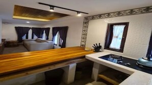 Uma cozinha compacta com bancada de madeira, fogão embutido e um espaço de refeições com banco.