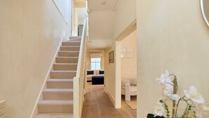 A staircase leading to a living area with a sofa and a coffee table. - The Arch & Lightwell - Chelsea (London)