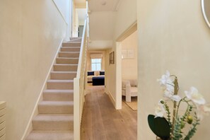 A staircase leading to a living area with a sofa and a coffee table. - The Arch & Lightwell - Chelsea (London)