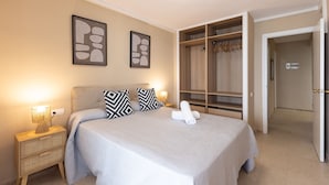 A bedroom with a bed, bedside tables, a wardrobe, and a hallway. - Beachfront | Spectacular sea views (La Pineda)