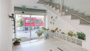 A modern interior with a staircase, potted plants, and a view of the outside. - Hotel Santiago (Rimini)