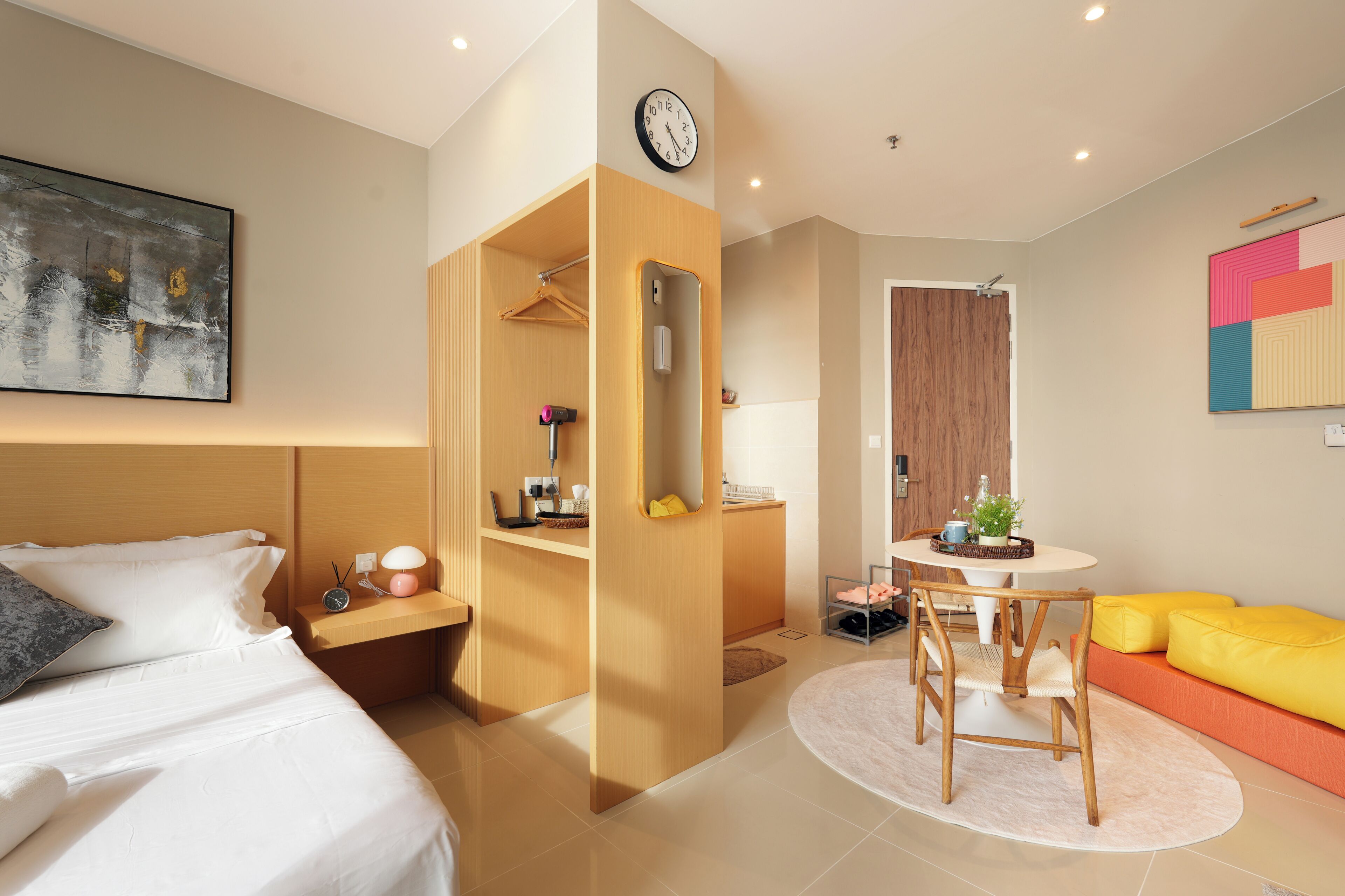 Una habitación de hotel con una cama, un escritorio, una silla, una mesa redonda y un sofá.