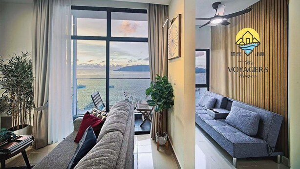 A modern living room with a sofa, a dining table, and a view of the sea. - The Voyagers Home Borneo Kota Kinabalu (Kota Kinabalu)