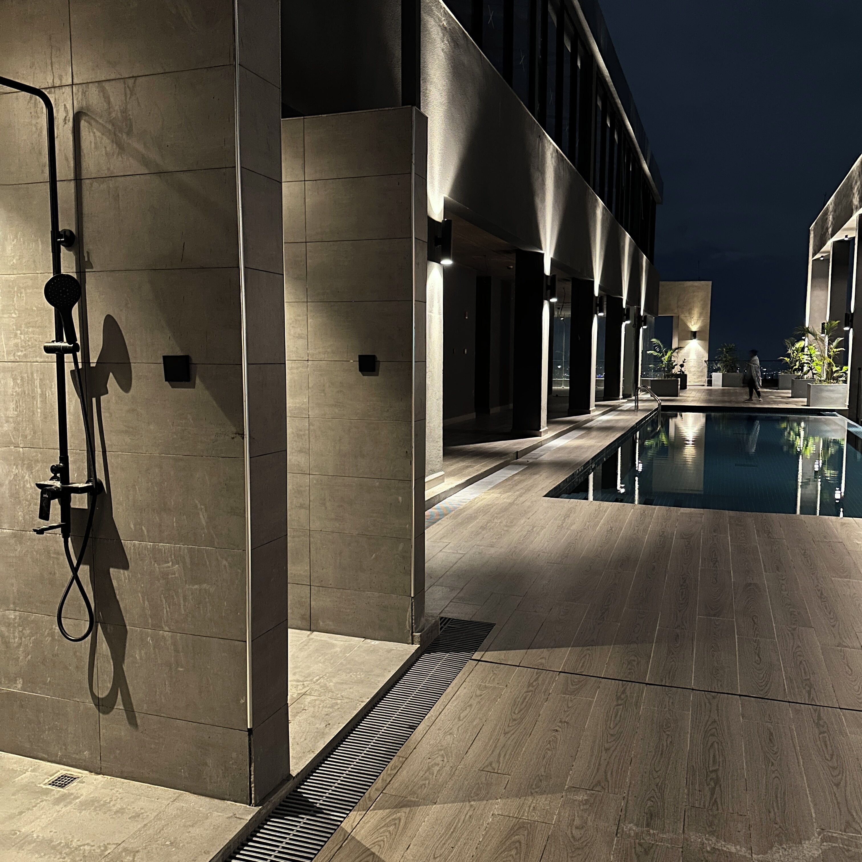 Edifici modern amb piscina, zona de dutxes i passatge ben il·luminat.