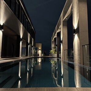 Una piscina al aire libre, tumbonas