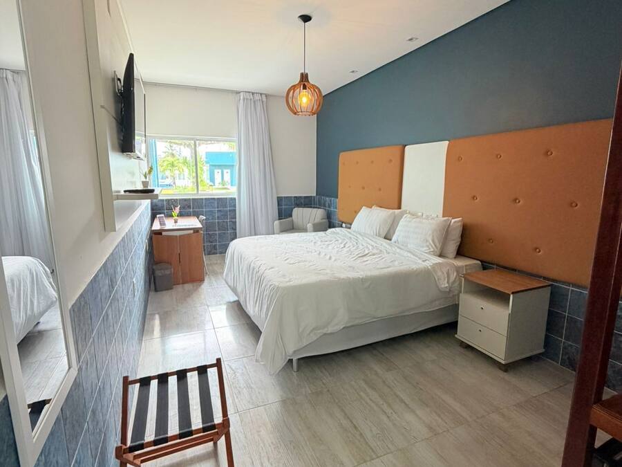 A modern bedroom with a bed, bedside table, and a small seating area.